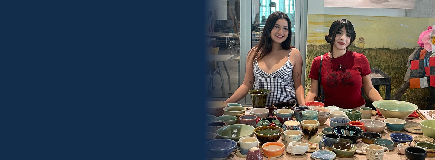 students behind table of ceramics